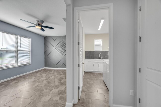 11461 SW Lyra Dr, Port Saint Lucie, FL 34987 - spare room featuring a ceiling fan, a sink, and baseboards
