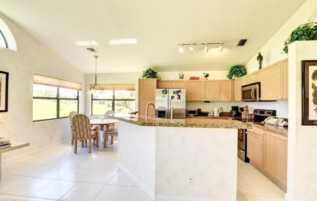 kitchen with a center island with sink, a healthy amount of sunlight, appliances with stainless steel finishes, and vaulted ceiling