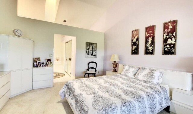 bedroom with light carpet, high vaulted ceiling, and ensuite bathroom