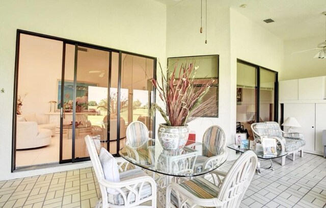 tiled living room with ceiling fan and vaulted ceiling