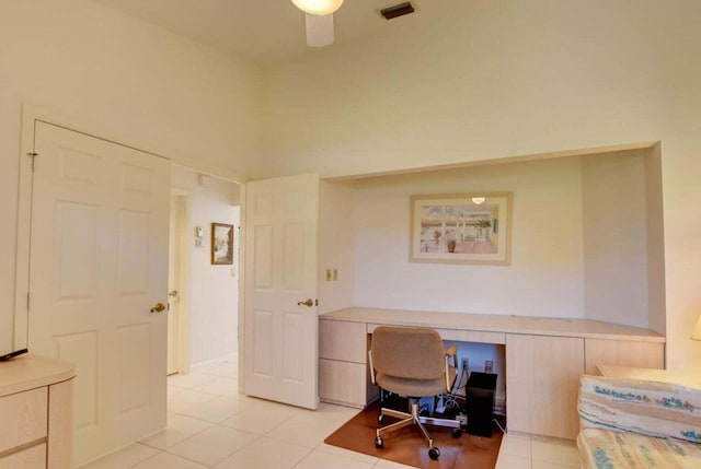 tiled home office featuring built in desk and ceiling fan