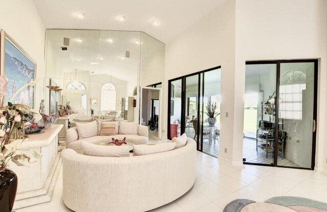 living room featuring light tile patterned flooring and high vaulted ceiling