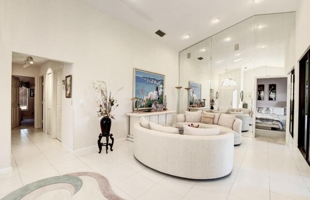 tiled dining space with a high ceiling and a notable chandelier