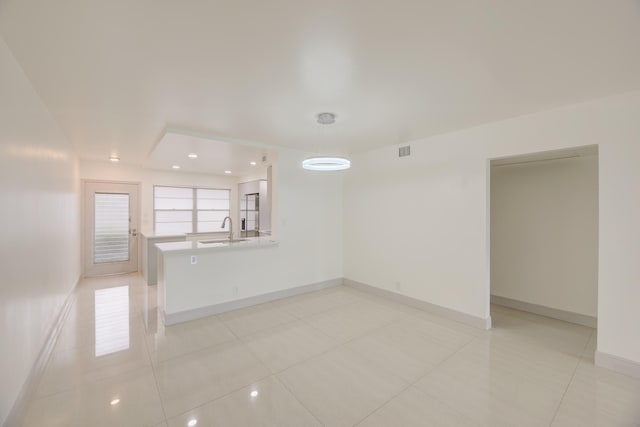 spare room featuring sink and light tile patterned floors