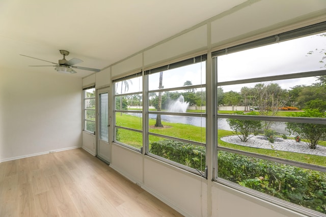 unfurnished sunroom featuring a water view and ceiling fan