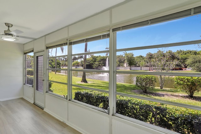 unfurnished sunroom with a water view and ceiling fan