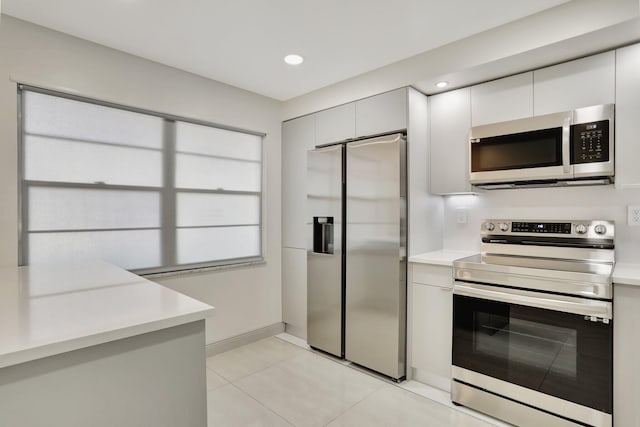 kitchen featuring white cabinets, light tile patterned floors, and appliances with stainless steel finishes