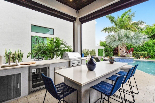 view of patio featuring wine cooler, a grill, area for grilling, and a bar