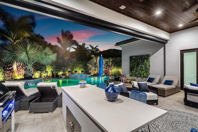 patio terrace at dusk with a swimming pool with hot tub and an outdoor hangout area