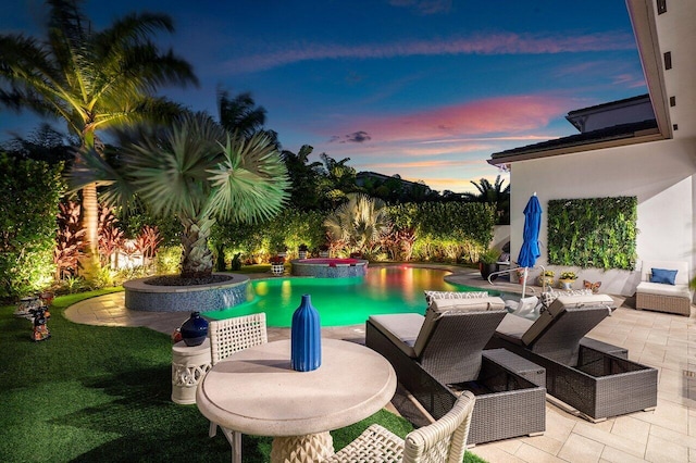 pool at dusk with a patio area