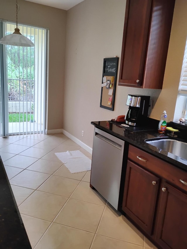 kitchen featuring pendant lighting, dishwasher, sink, dark stone countertops, and light tile patterned floors