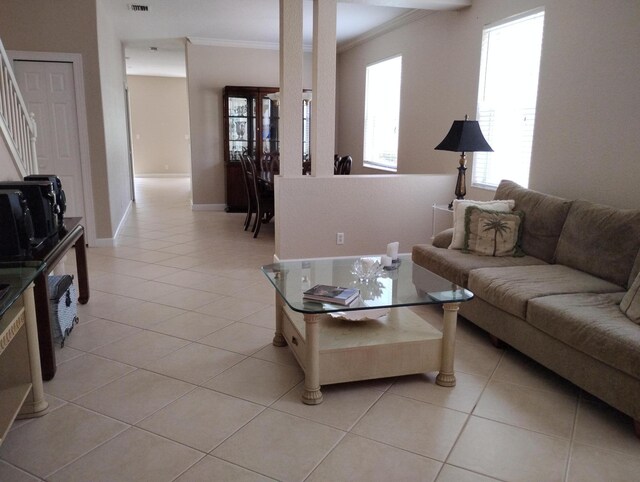 living room with light tile patterned floors and ornamental molding