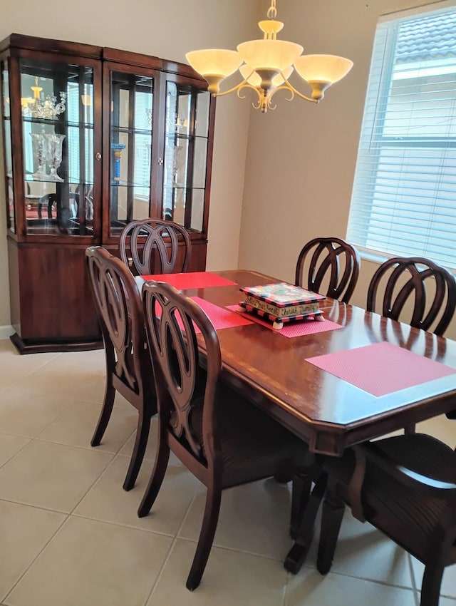 dining area with light tile patterned flooring and a chandelier