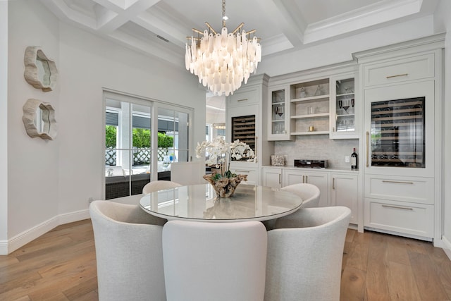 dining area with light wood-type flooring, coffered ceiling, and wine cooler