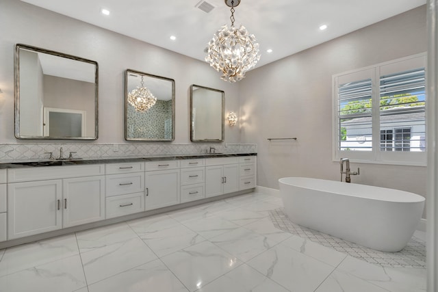 bathroom with a bathing tub, decorative backsplash, vanity, and a chandelier