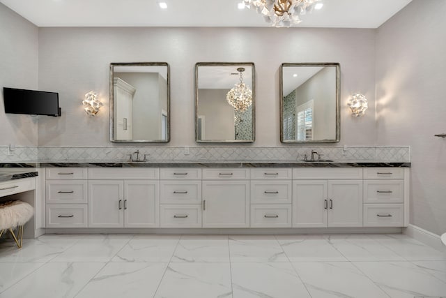 bathroom with decorative backsplash, vanity, and a chandelier