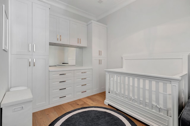 bedroom with light hardwood / wood-style floors, a closet, and ornamental molding