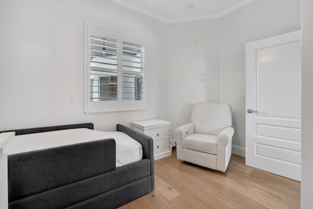 bedroom with light hardwood / wood-style flooring and crown molding