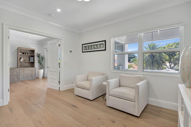 living area featuring light wood-type flooring and ornamental molding