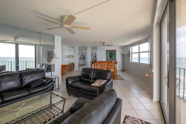 living room featuring a water view, a healthy amount of sunlight, and a textured ceiling