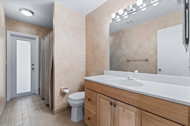 bathroom with a shower with curtain, tile patterned flooring, vanity, and toilet