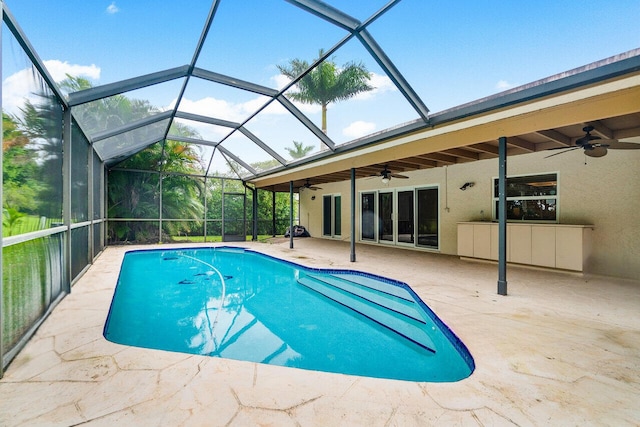 view of swimming pool featuring ceiling fan, a lanai, and a patio