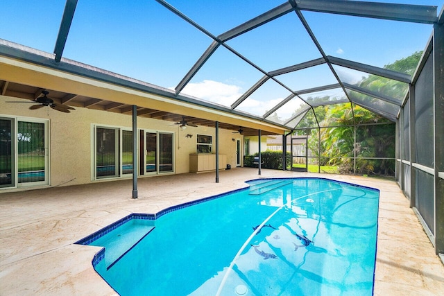 view of swimming pool with ceiling fan, a lanai, and a patio