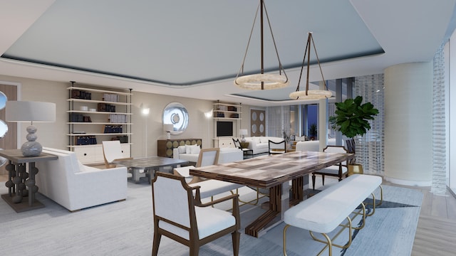 dining room with light wood-type flooring and a tray ceiling