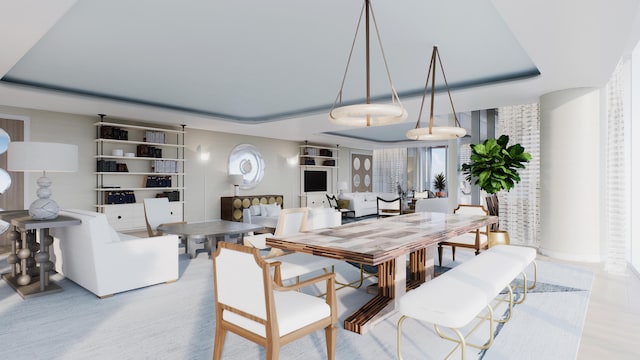 dining area featuring light wood-type flooring and a tray ceiling