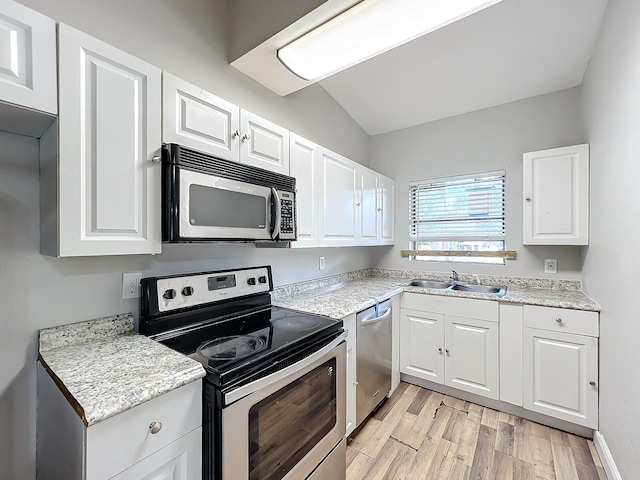 kitchen featuring white cabinets, appliances with stainless steel finishes, sink, and vaulted ceiling