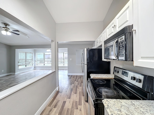 kitchen with light stone counters, ceiling fan, white cabinets, black / electric stove, and light wood-type flooring