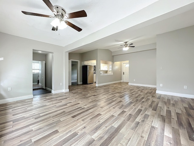 unfurnished living room featuring ceiling fan and light hardwood / wood-style floors