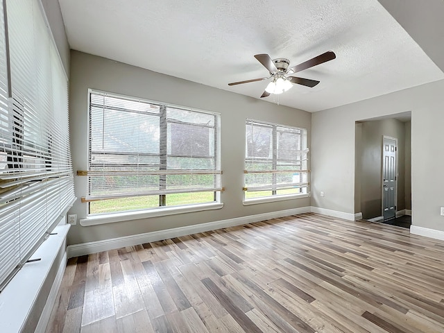 interior space with a textured ceiling, light hardwood / wood-style floors, and ceiling fan