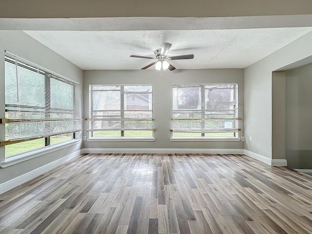 unfurnished sunroom with ceiling fan