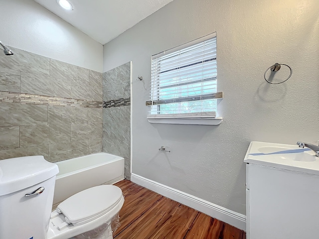 full bathroom with hardwood / wood-style flooring, vanity, toilet, and tiled shower / bath combo