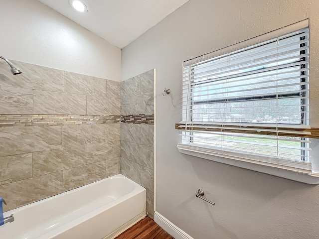 bathroom featuring hardwood / wood-style floors and tiled shower / bath