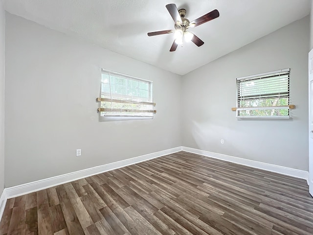 spare room featuring dark wood-type flooring, ceiling fan, and vaulted ceiling