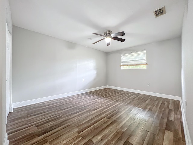 spare room featuring dark wood-type flooring and ceiling fan