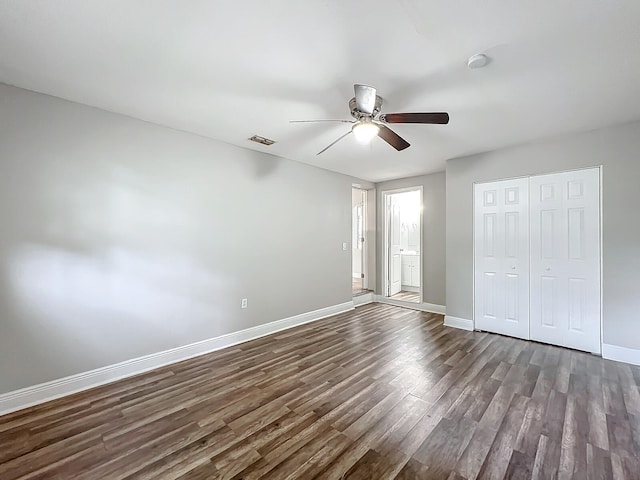 unfurnished bedroom featuring ceiling fan, dark hardwood / wood-style floors, and a closet