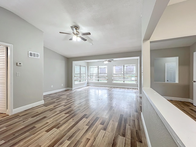 unfurnished living room with wood-type flooring, ceiling fan, and a textured ceiling