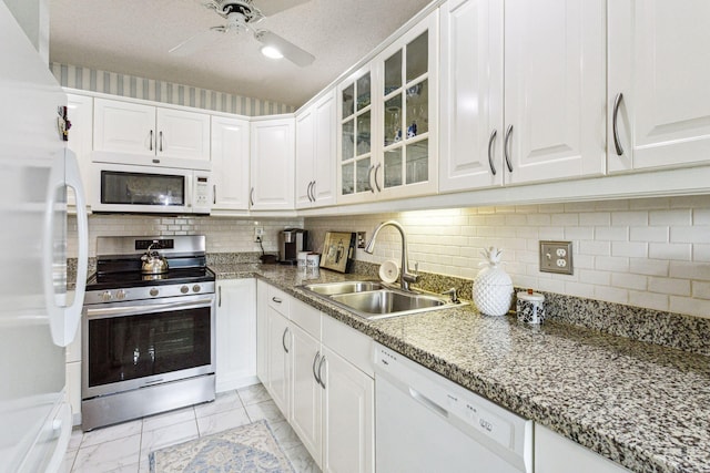 kitchen featuring sink, a textured ceiling, backsplash, white appliances, and white cabinets