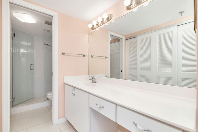 bathroom with toilet, vanity, an enclosed shower, and tile patterned flooring