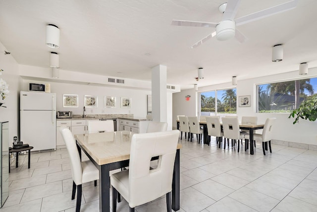 dining room with ceiling fan, sink, and light tile patterned floors