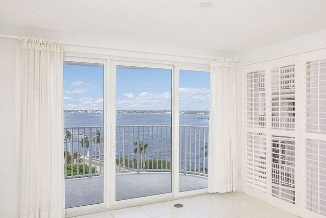 interior space with light tile patterned floors and a water view