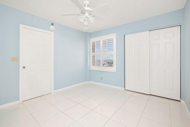 unfurnished bedroom with a closet, light tile patterned flooring, and ceiling fan