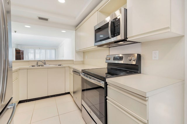 kitchen featuring appliances with stainless steel finishes, sink, and light tile patterned floors