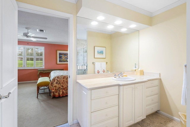 bathroom with ceiling fan, vanity, a textured ceiling, and ornamental molding