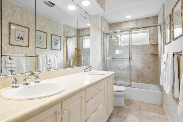 full bathroom with toilet, vanity, and shower / bath combination with glass door