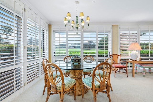 dining room with light colored carpet, a healthy amount of sunlight, a chandelier, and ornamental molding