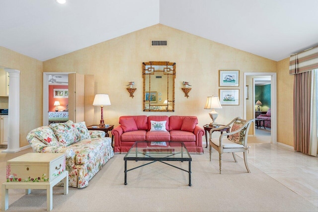 living room featuring lofted ceiling and decorative columns